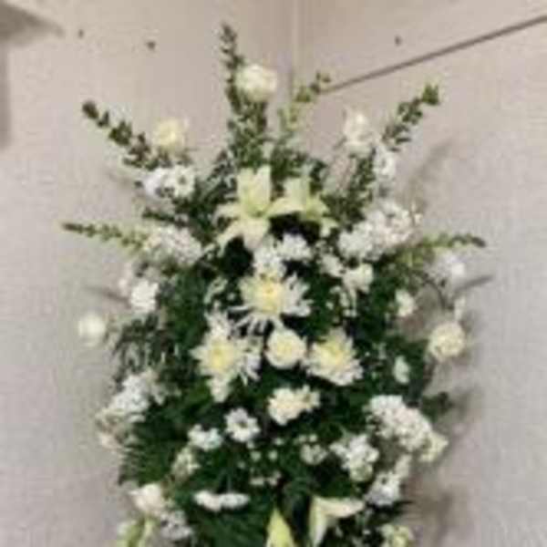 Tall white floral standing spray on an easel