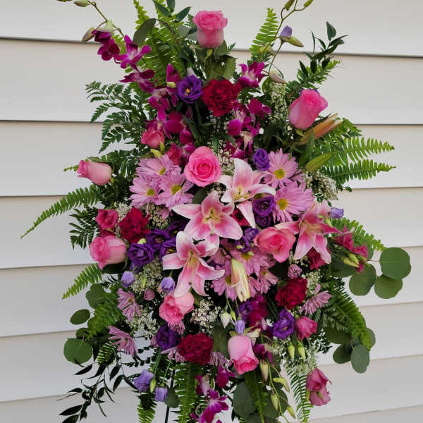Tall standing floral spray with pink and purple blooms on a metal easel