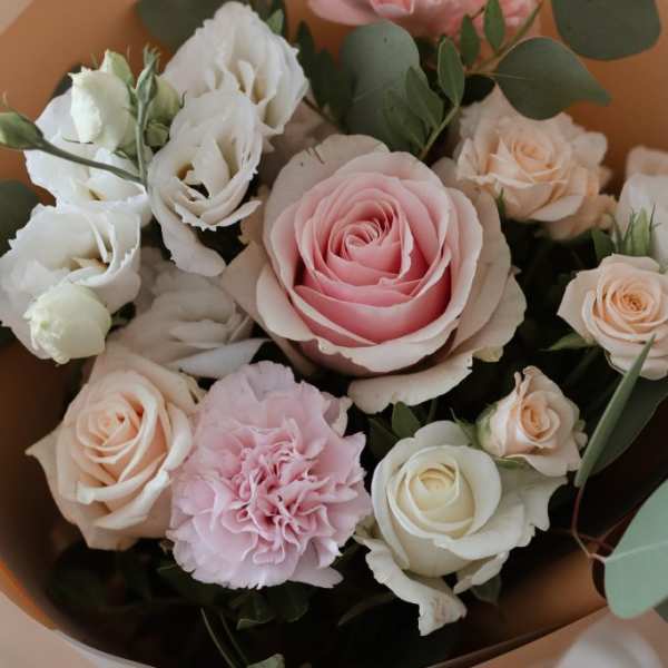 Bouquet of pink and white roses with eucalyptus in tan wrap