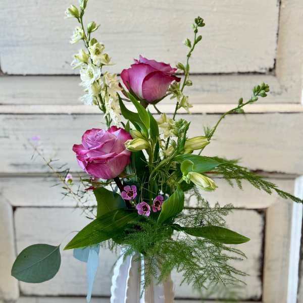 Pink roses and white flowers in a white vase