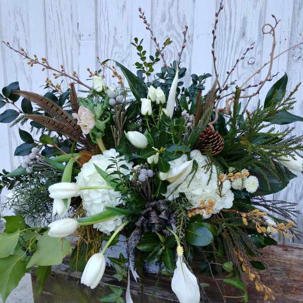 Large white floral arrangement with tulips, hydrangeas, and branches