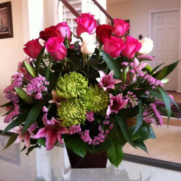 Bouquet of pink roses, lilies, and green chrysanthemums in a vase