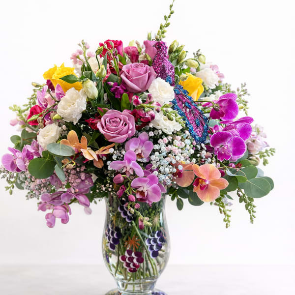 Mixed bouquet of roses and orchids in a clear glass vase