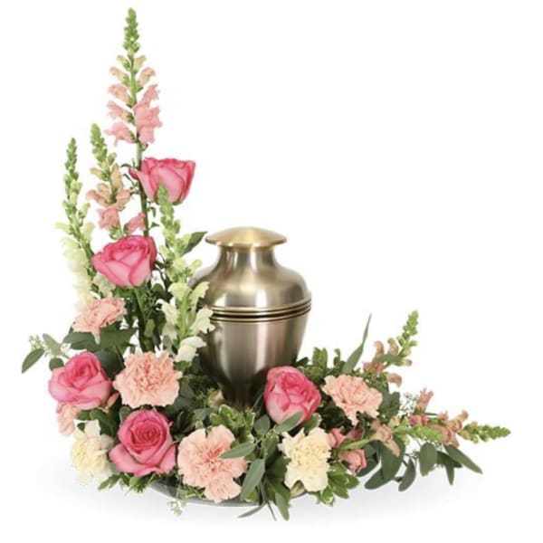Pink roses and carnations arranged around a gold urn