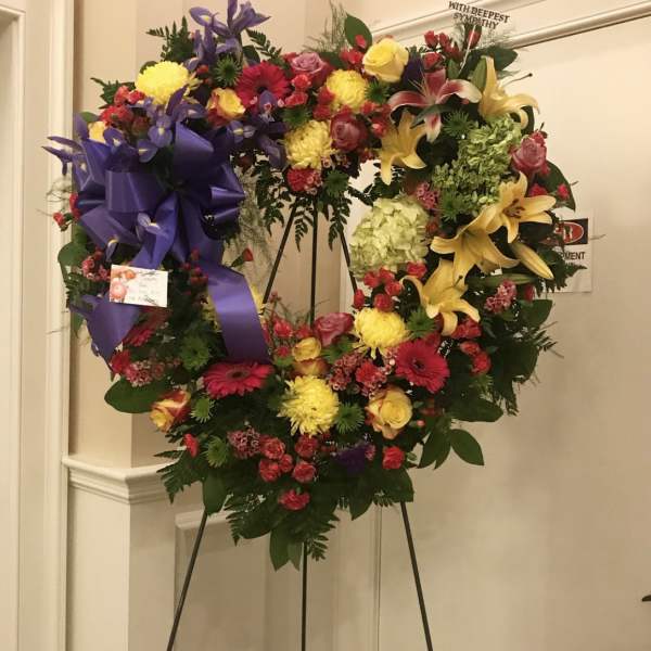 Large heart-shaped sympathy wreath with mixed flowers on an easel
