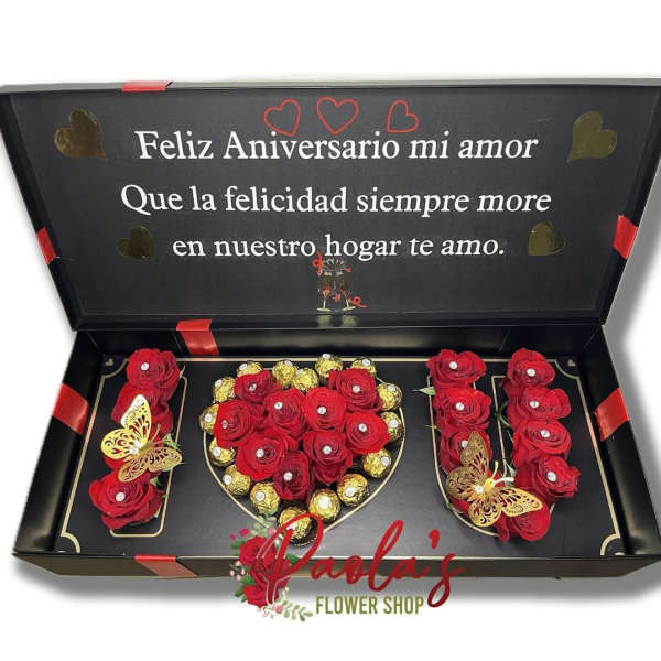 Black gift box with red roses and gold chocolates arranged as a heart and letters