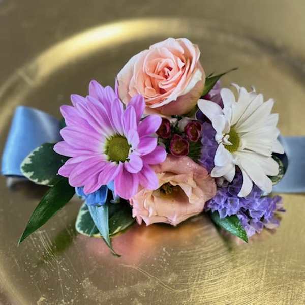 Small corsage with pink and white flowers on a blue ribbon