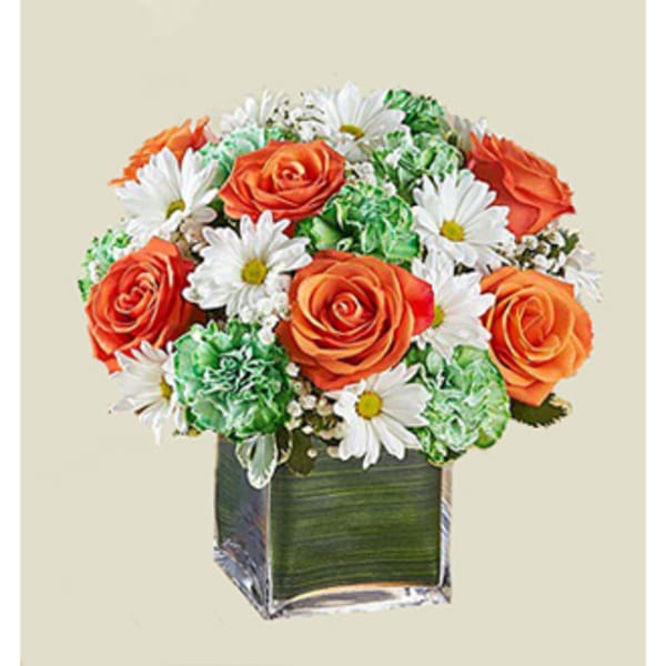 Orange roses and white daisies in a square glass vase
