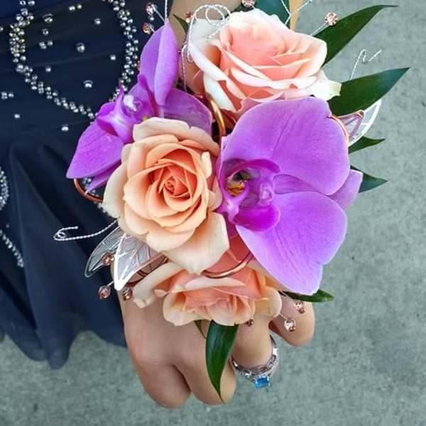 Handheld corsage with peach roses and purple orchids