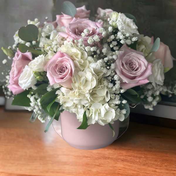 Pink and white rose bouquet in a round blush vase