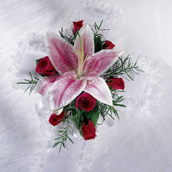 Pink lily and red rose boutonniere on white fabric