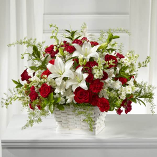 Red roses and white lilies arranged in a white basket