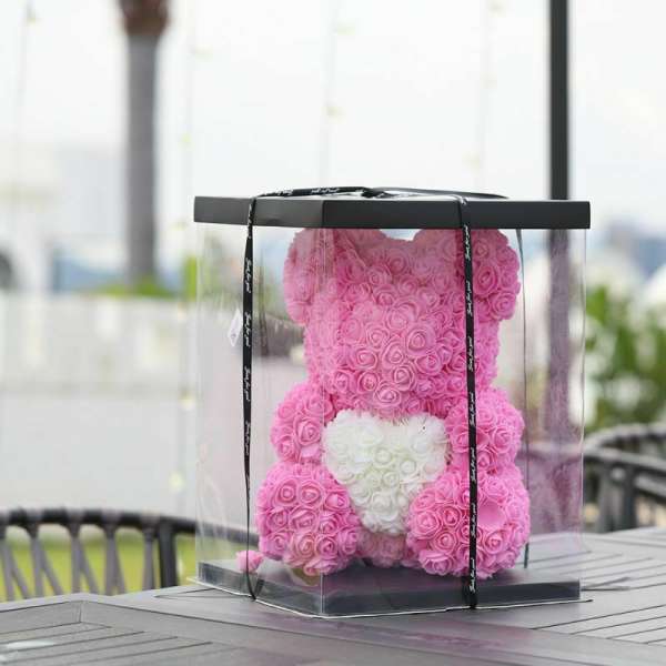 Pink rose teddy bear in a clear gift box with a white heart