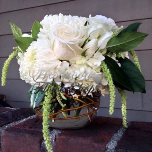 White rose and chrysanthemum arrangement in a woven vase