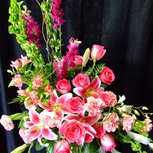 Tall pink floral arrangement with roses, lilies, and carnations