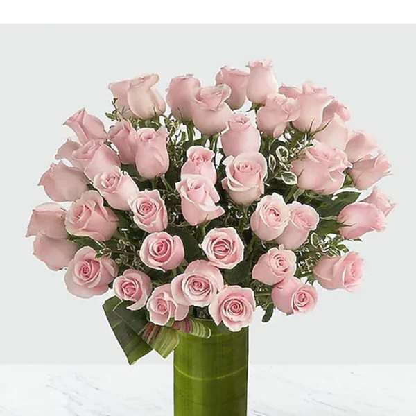 Pink roses arranged in a tall green vase