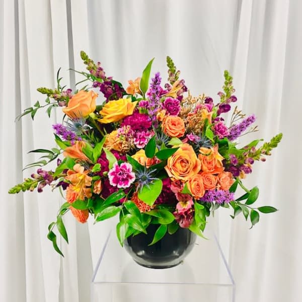 Colorful mixed flower arrangement in a black vase