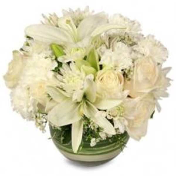 White floral arrangement in a green glass bowl vase