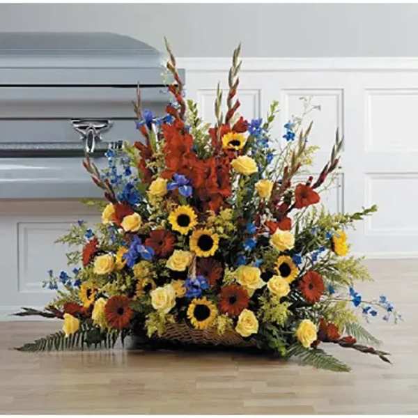 Large basket arrangement with sunflowers, roses, and blue flowers