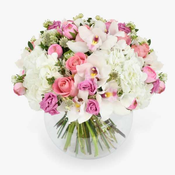 Pink and white bouquet of roses, orchids, and hydrangeas in a clear vase