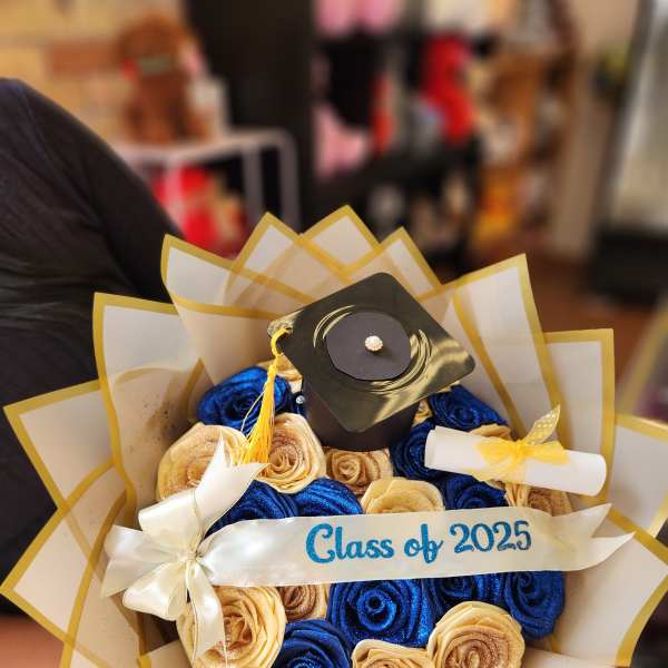 Graduation bouquet with blue and gold roses and a cap topper
