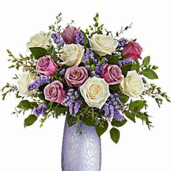 Bouquet of pink and white roses in a lavender vase