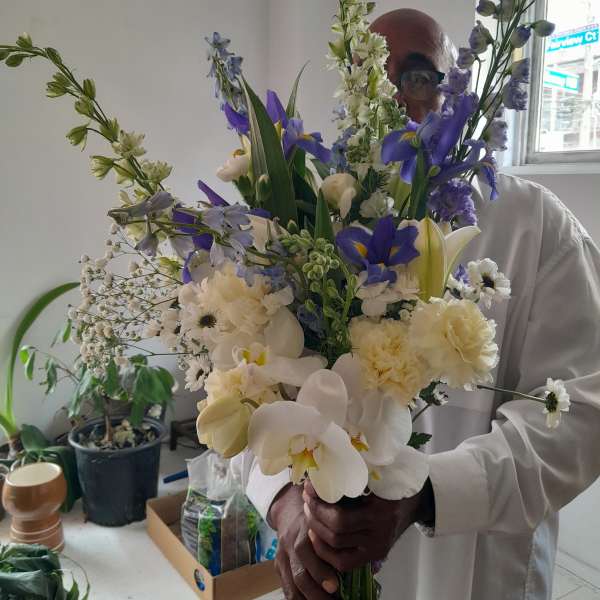 Large bouquet of white and purple flowers held by a person