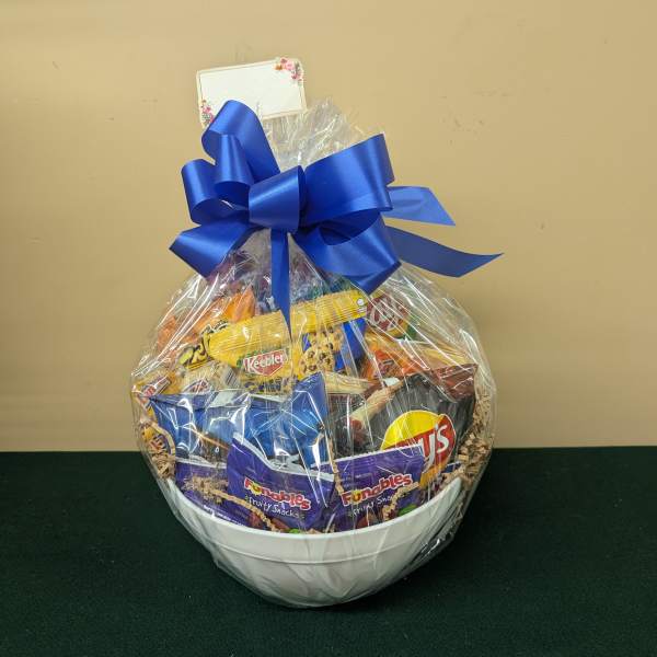 Gift basket of assorted snacks in a white bowl with a blue bow