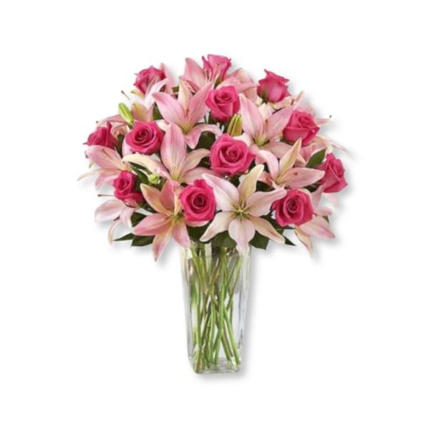 Pink roses and lilies arranged in a clear glass vase