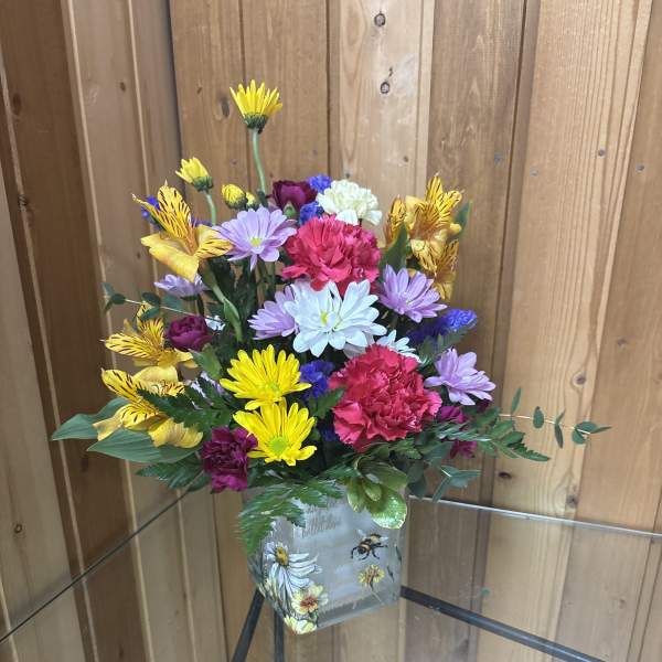 Colorful bouquet in a decorated square glass vase