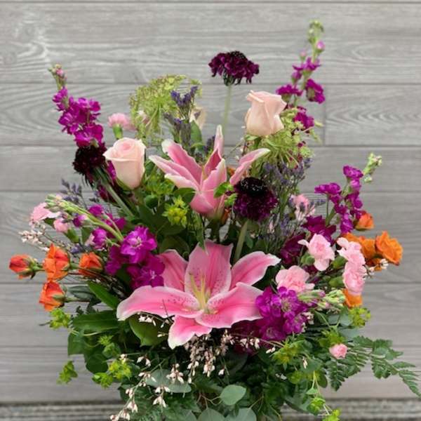 Mixed bouquet with pink lilies and roses in a glass vase