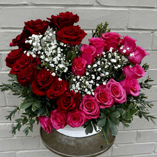 Bouquet of red and pink roses with white baby's breath in a vase