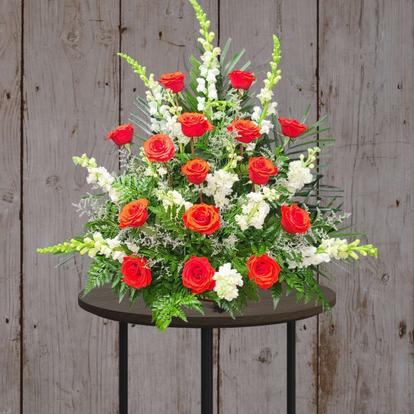 Red roses and white flowers in a large standing arrangement