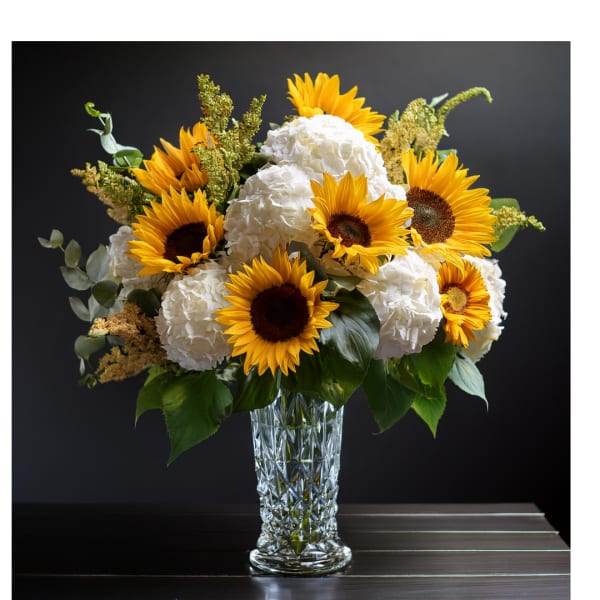 Sunflowers and white hydrangeas in a clear glass vase