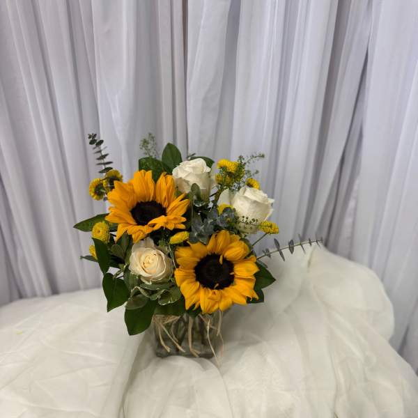 Bouquet of sunflowers and white roses in a glass vase
