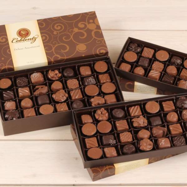 Boxes of assorted chocolates on a light wood surface