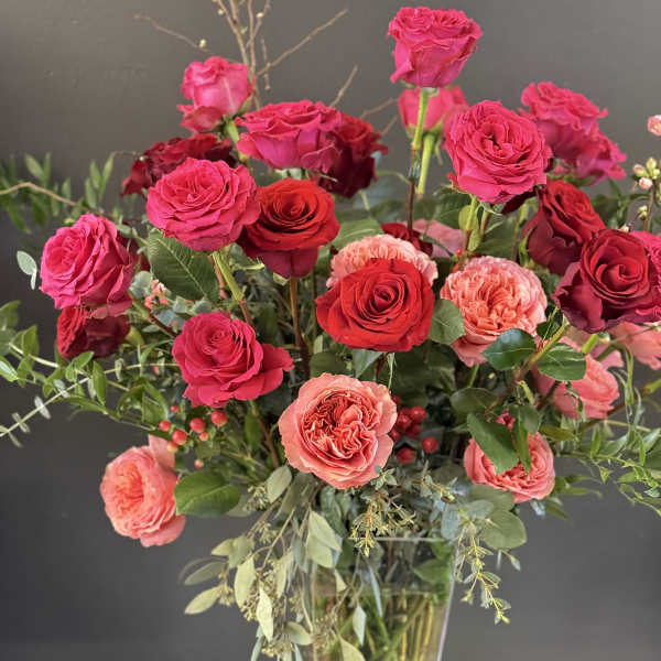 Tall bouquet of pink and red roses in a clear glass vase