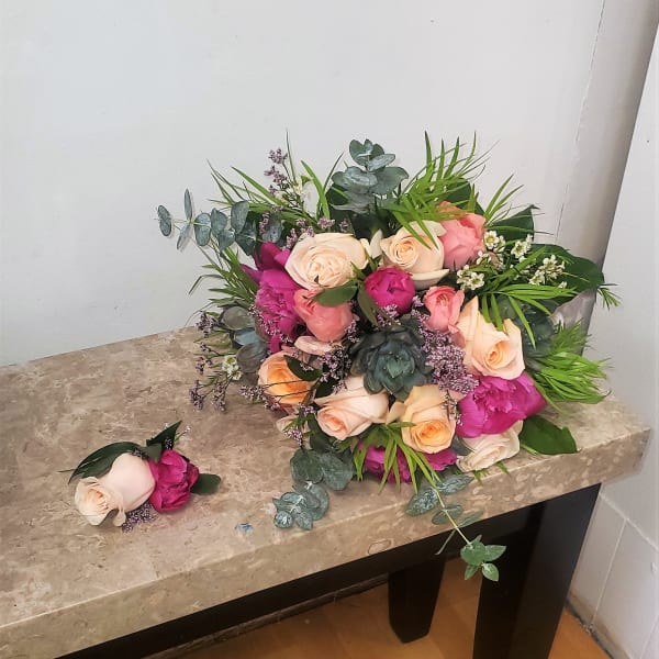 Bouquet of blush and pink roses with greenery on a stone table