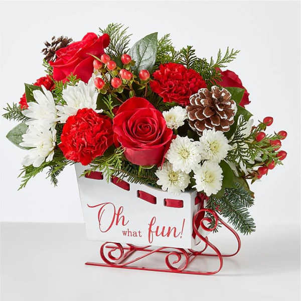 Red and white floral arrangement in a sleigh-shaped container