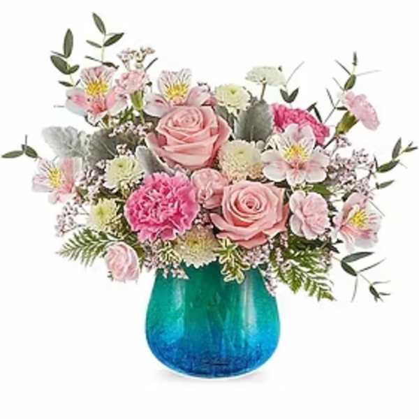 Pink and white mixed flower arrangement in a blue glass vase