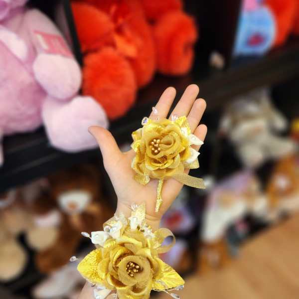 Pair of gold floral wrist corsages with white accents