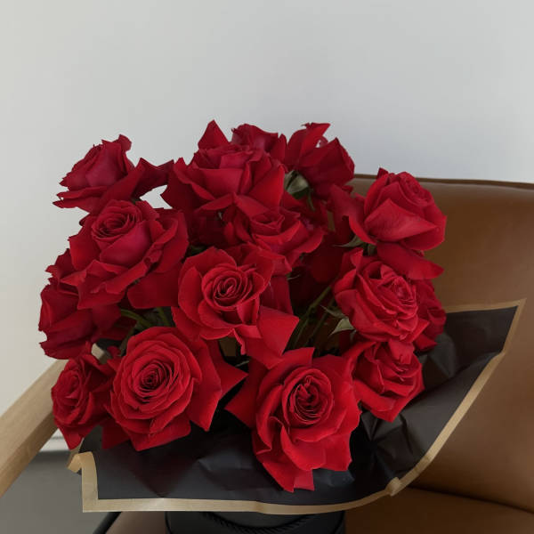 Bouquet of red roses wrapped in black paper