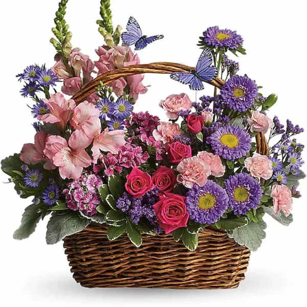Basket of pink and purple flowers with butterfly decorations