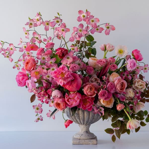 Pink floral arrangement in a stone urn vase