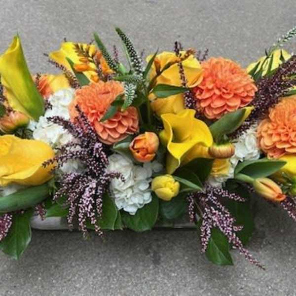 Yellow and orange floral centerpiece with calla lilies and mums