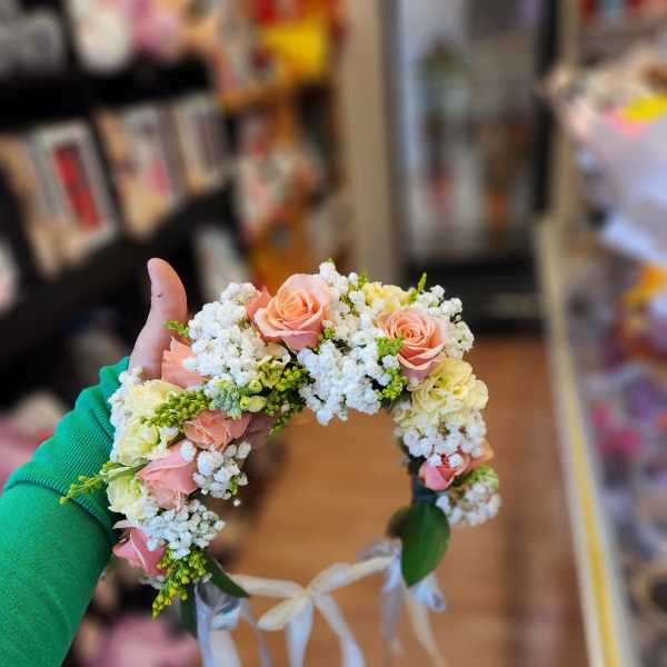 Floral crown with pink roses and white filler flowers tied with ribbons