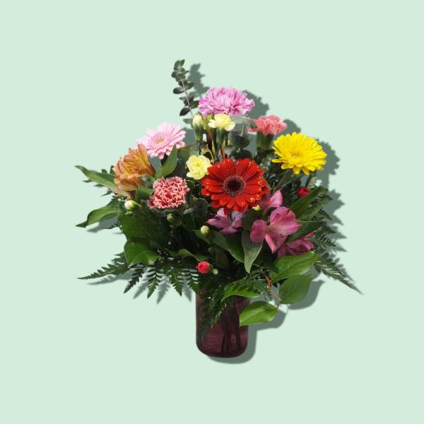 Mixed bouquet of colorful flowers in a purple vase