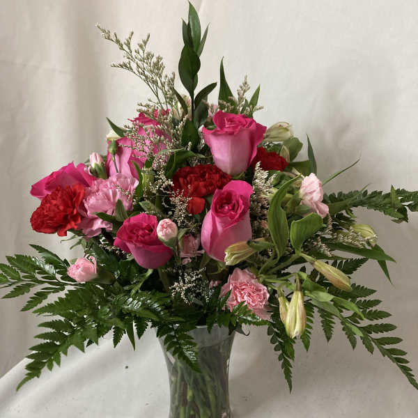Pink and red flower arrangement in a clear glass vase
