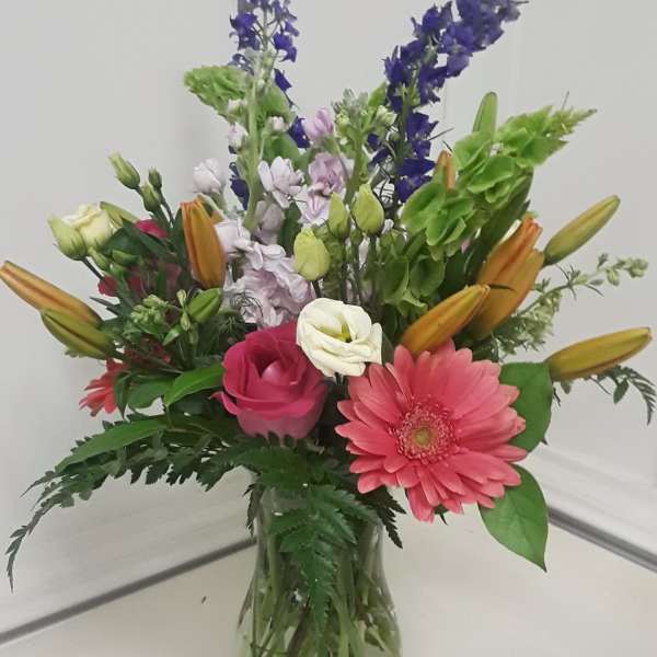 Mixed bouquet in a glass vase with pink gerbera daisies and lilies