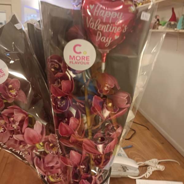 Wrapped orchid bouquet with a heart-shaped Valentine's Day balloon